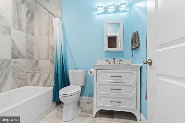 a bathroom with a sink mirror vanity and toilet