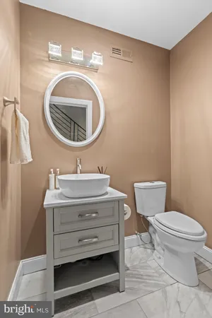 a bathroom with a toilet a sink and mirror