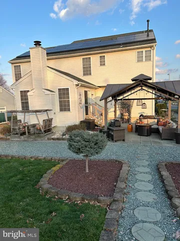 a kitchen with stainless steel appliances kitchen island granite countertop a stove a refrigerator a sink a dining table and chairs with wooden floor