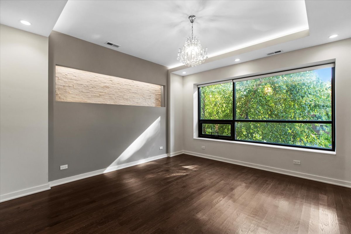 6900 North Sheridan Road, Unit 3E Chicago, IL 60626 - Photo 3 of 10 a view of an empty room with wooden floor and a window