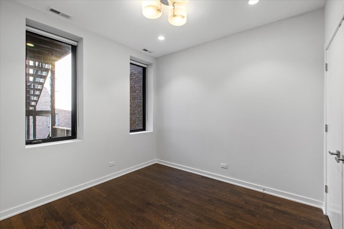 6900 North Sheridan Road, Unit 3E Chicago, IL 60626 - Photo 6 of 10 a view of an empty room with wooden floor and a window