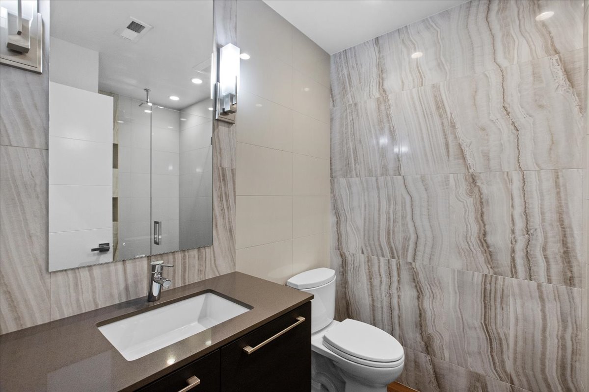 6900 North Sheridan Road, Unit 3E Chicago, IL 60626 - Photo 7 of 10 a bathroom with a sink a toilet a mirror and shower curtain