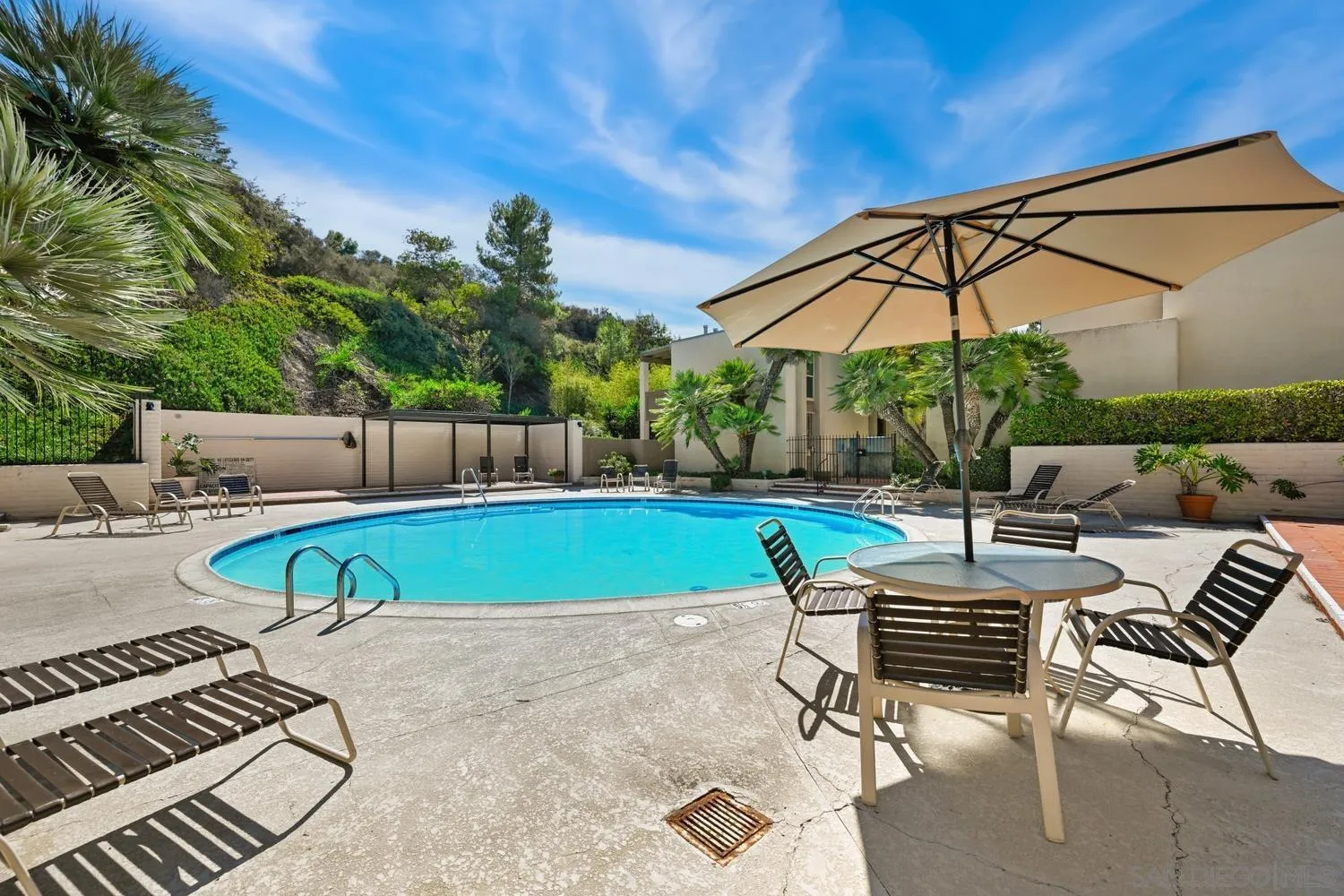 4881 Collwood Boulevard, Unit A San Diego, CA 92115 - Photo 20 of 25 a view of pool with lawn chairs under an umbrella