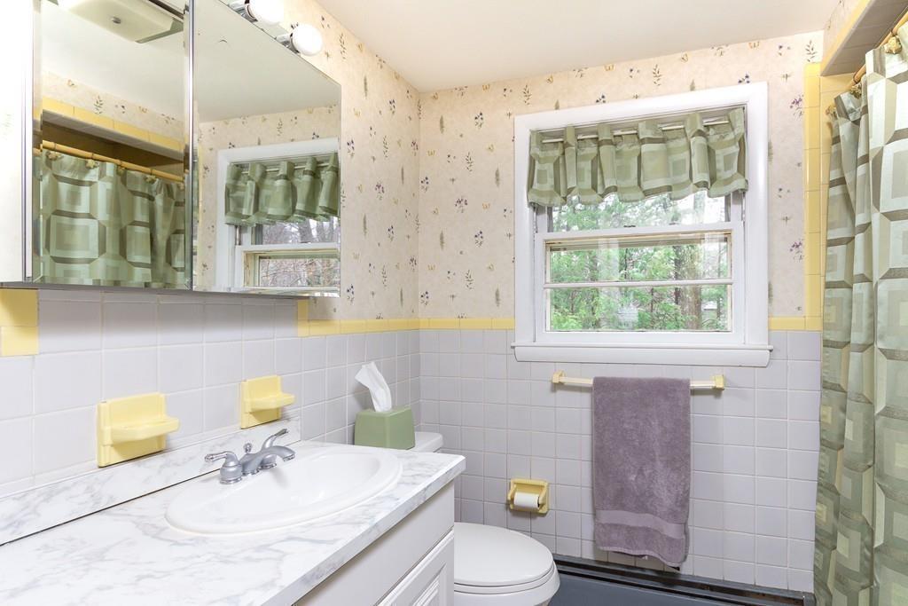 10 Kelch Road Reading, MA 01867 - Photo 15 of 16 a bathroom with a sink a toilet and shower curtain