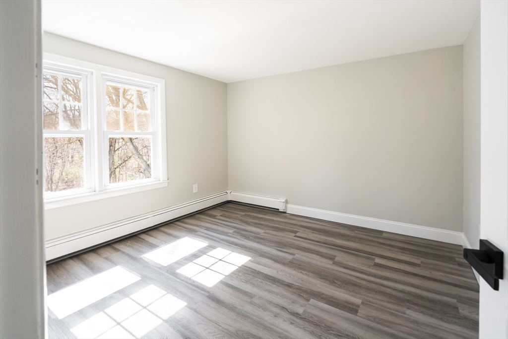 1049 Pleasant Street Canton, MA 02021 - Photo 21 of 34 an empty room with wooden floor and windows