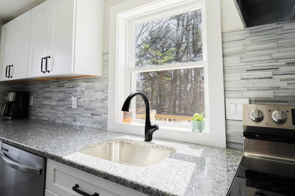 1049 Pleasant Street Canton, MA 02021 - Photo 5 of 34 a kitchen with granite countertop a sink and a stove