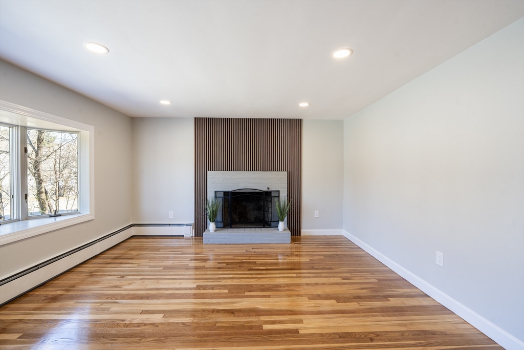 1049 Pleasant Street Canton, MA 02021 - Photo 8 of 34 a view of an empty room with a fireplace and a window
