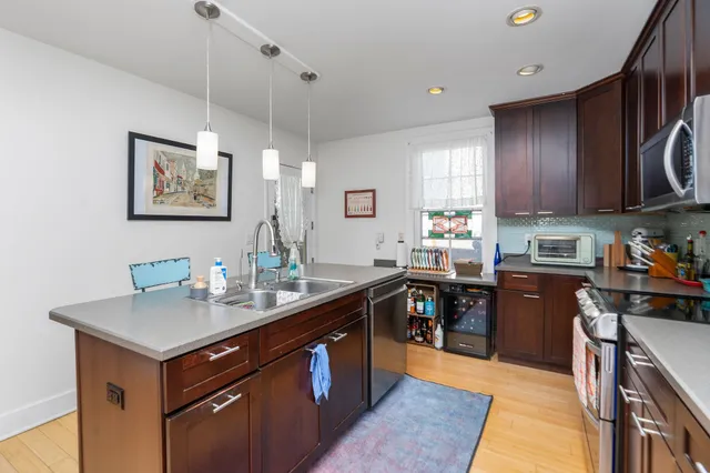 a kitchen with kitchen island granite countertop a sink counter top space and appliances