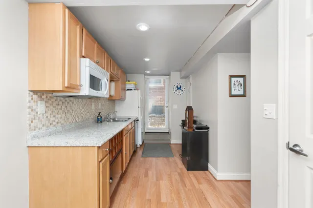 a kitchen with a sink and wooden floor