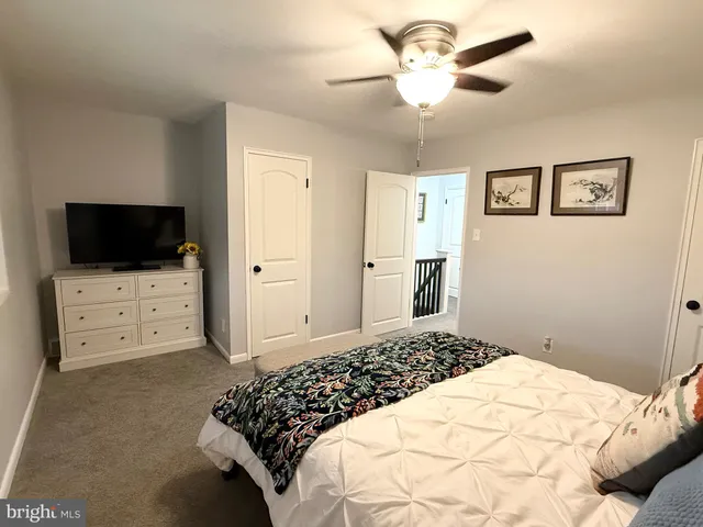 a bedroom with a bed and a flat tv screen on dresser