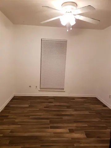 a view of a room with wooden floor and a ceiling fan