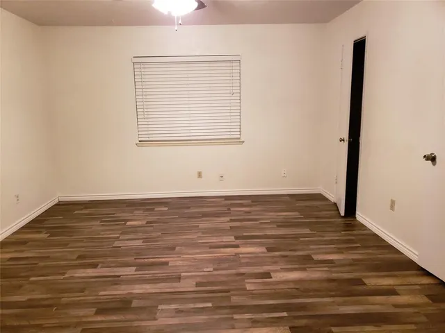 a view of a room with wooden floor and a window