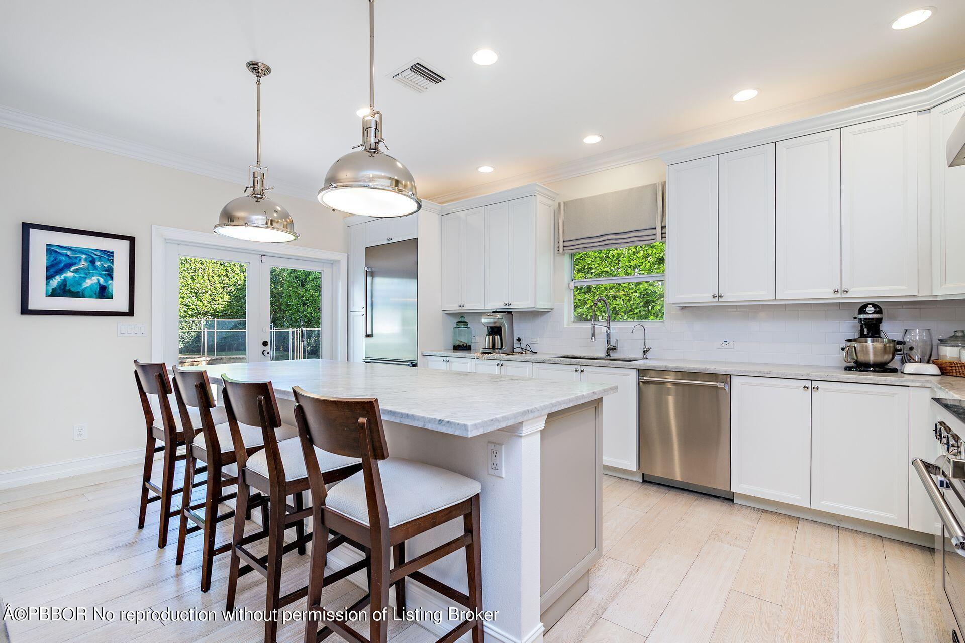 230 Alpine Road West Palm Beach, FL 33405 - Photo 11 of 31 a kitchen with a dining table chairs sink and cabinets