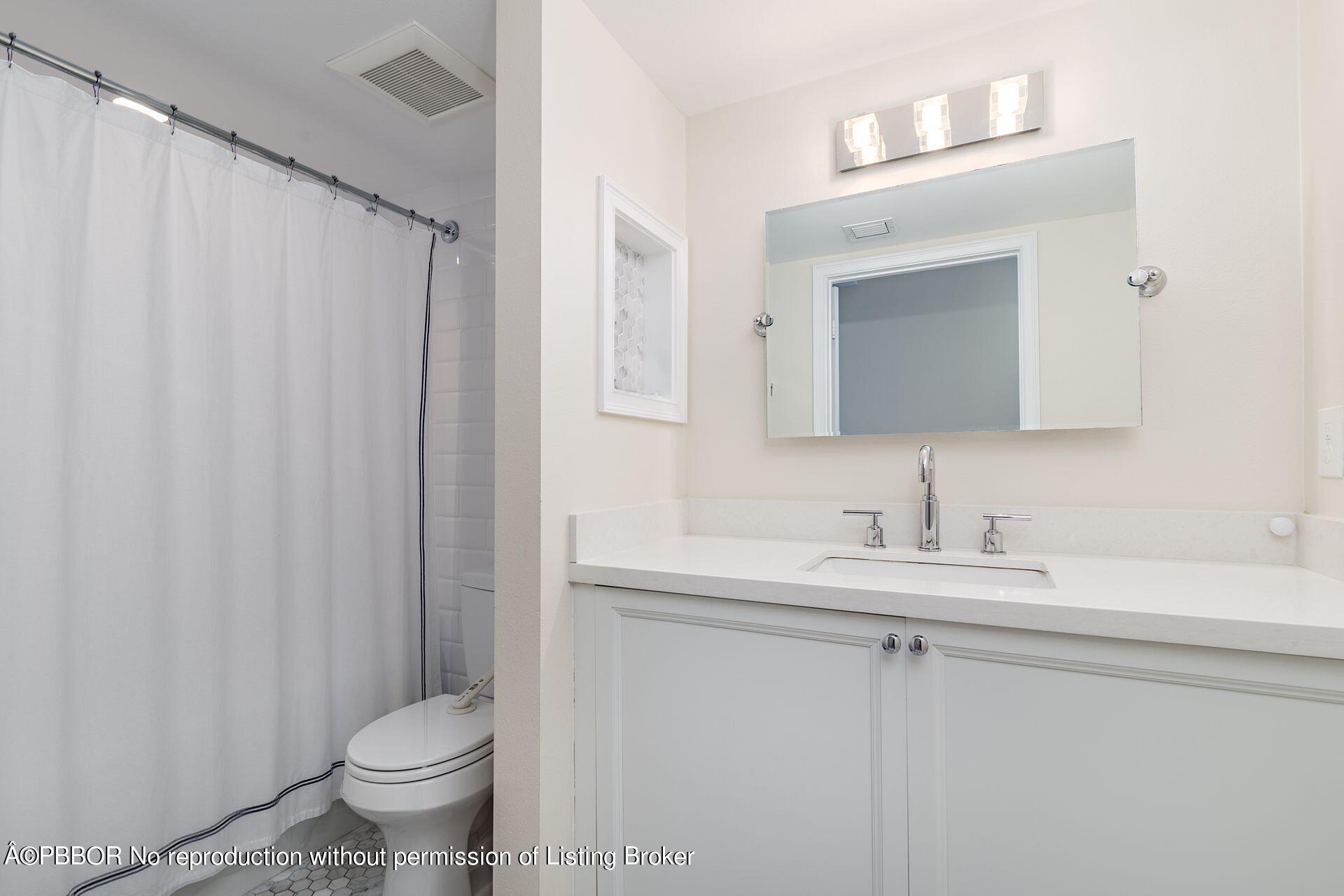 230 Alpine Road West Palm Beach, FL 33405 - Photo 18 of 31 a bathroom with a toilet a sink and a mirror
