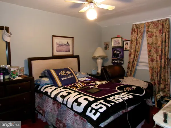 a bed sitting in a bedroom next to a window with a desk and chair