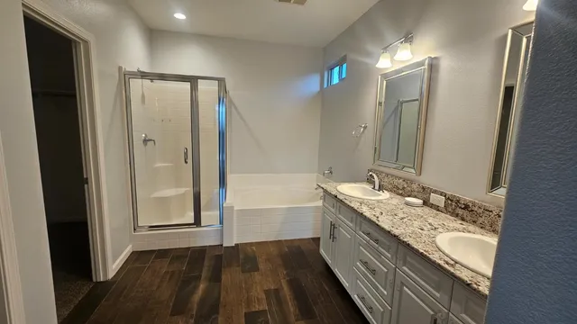 a bathroom with a tub shower and sink