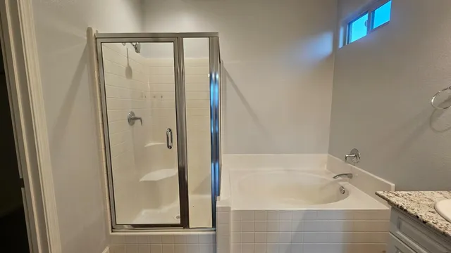 a bathroom with a sink double vanity granite tub and shower