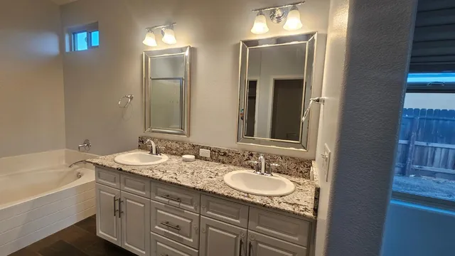 a bathroom with a double vanity sink and a mirror