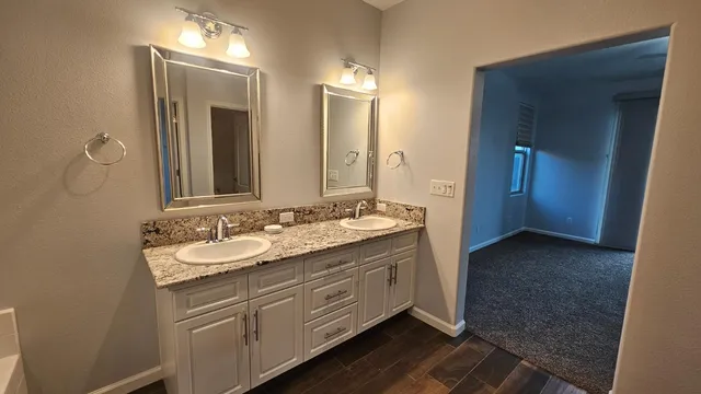 an empty room with chandelier fan and windows