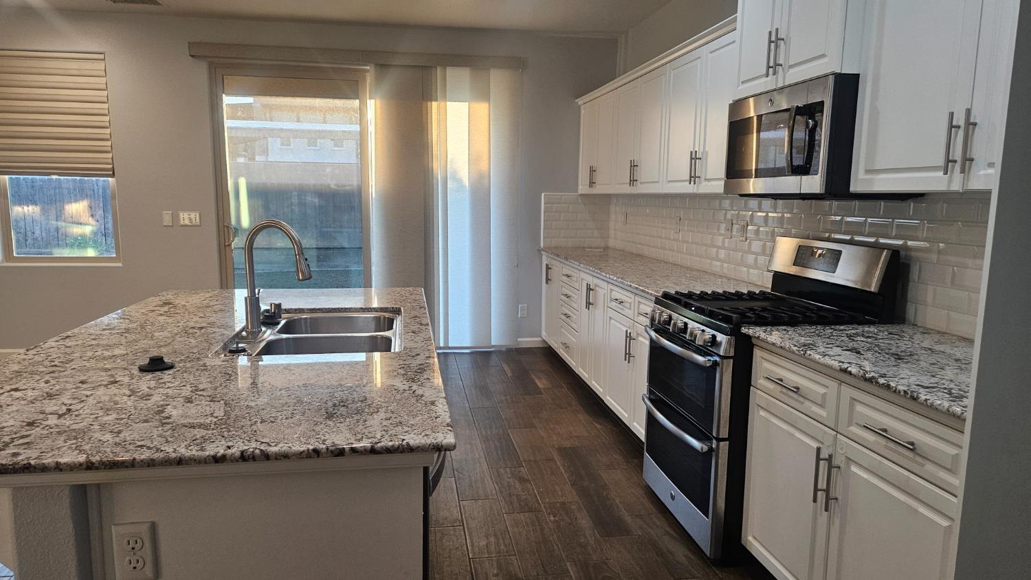 3351 Cordova Avenue Clovis, CA 93619 - Photo 20 of 33 a kitchen with stainless steel appliances granite countertop a stove a sink and a microwave