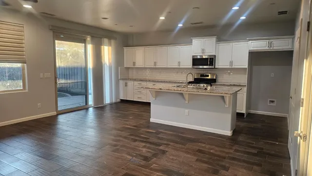 a view of a kitchen with a dishwasher cabinets and a large window