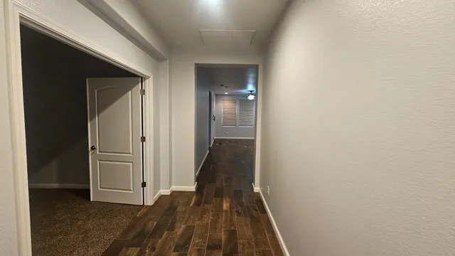 a view of a hallway with wooden floor and closet