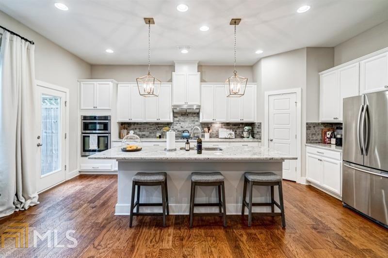 a kitchen with kitchen island stainless steel appliances a dining table and chairs