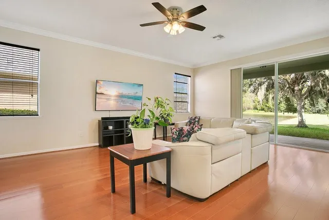 a living room with furniture a flat screen tv and a large window