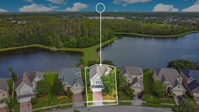 an aerial view of a house with a yard and lake view