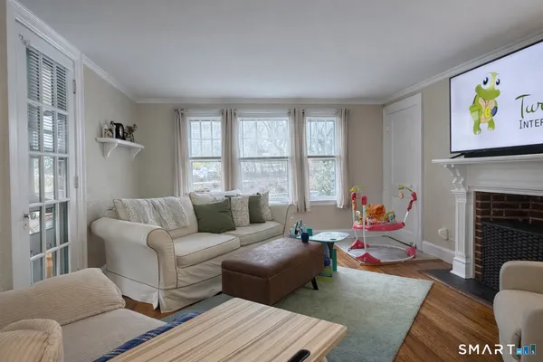 a living room with furniture two window and a fireplace