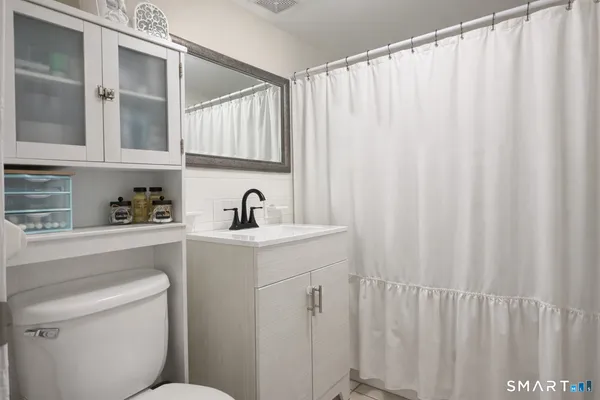 a bathroom with a sink a toilet and shower curtain