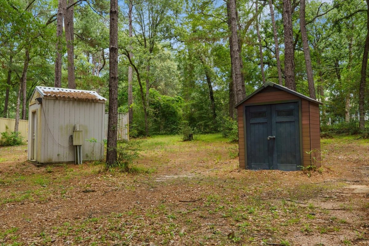 16375 Grand Flower Road Plantersville, TX 77363 - Photo 36 of 50 a house with trees in the background