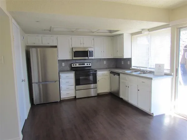 a kitchen with stainless steel appliances a refrigerator sink and microwave