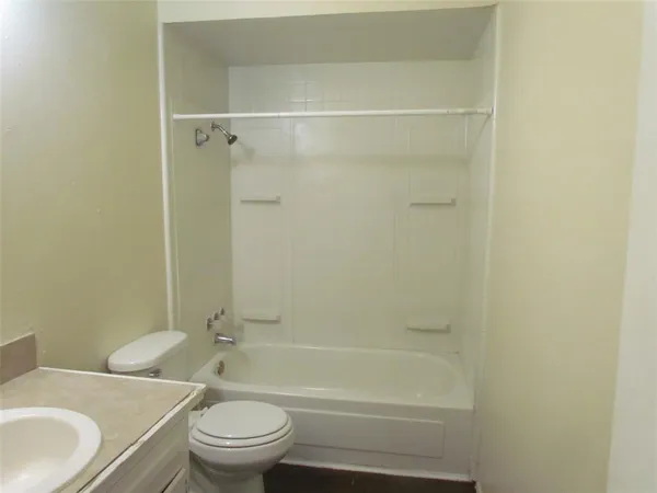 a bathroom with a granite countertop toilet a sink and a bathtub