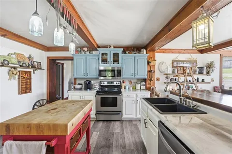 a kitchen with stainless steel appliances granite countertop a sink a stove and a refrigerator