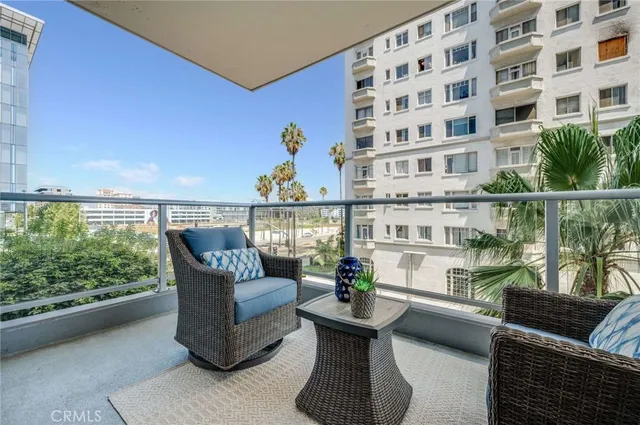 a view of a patio with couches chairs potted plants and wooden floor
