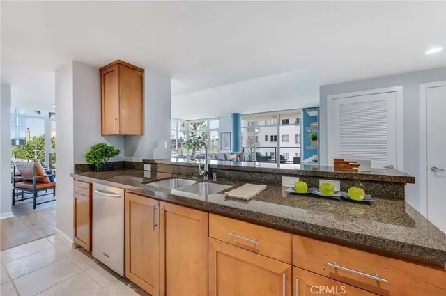 a kitchen with kitchen island granite countertop stainless steel appliances a sink and a counter top space