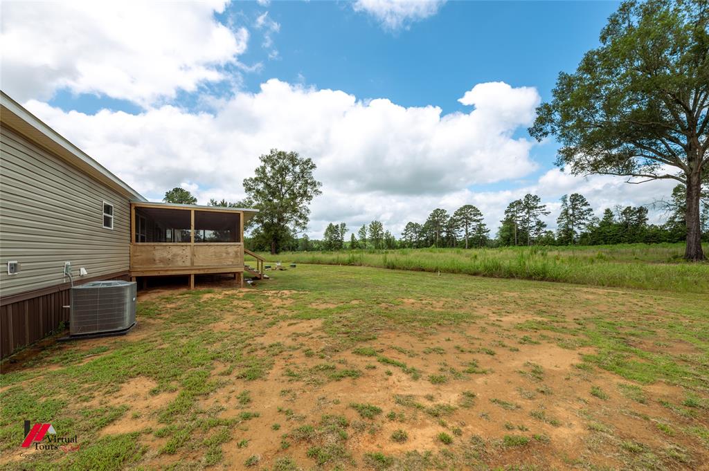 810 Chalybeate Springs Road Plain Dealing, LA 71064 - Photo 5 of 38 Back Yard with Fully Screened-In Back Porch