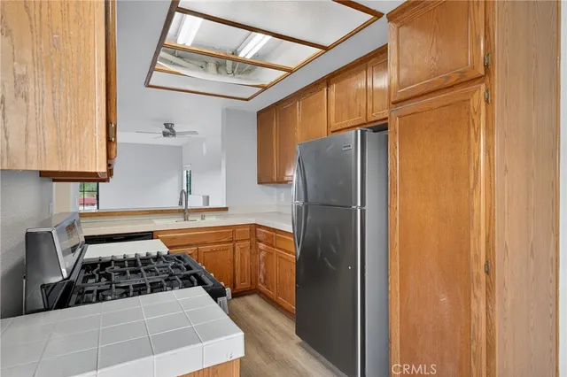 a kitchen with stainless steel appliances granite countertop a sink and a refrigerator