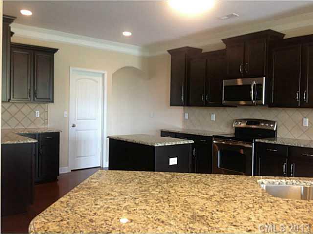 78004 Rillstone Drive, Unit 181 Lancaster, SC 29720 - Photo 6 of 13 a kitchen with granite countertop a stove and a refrigerator