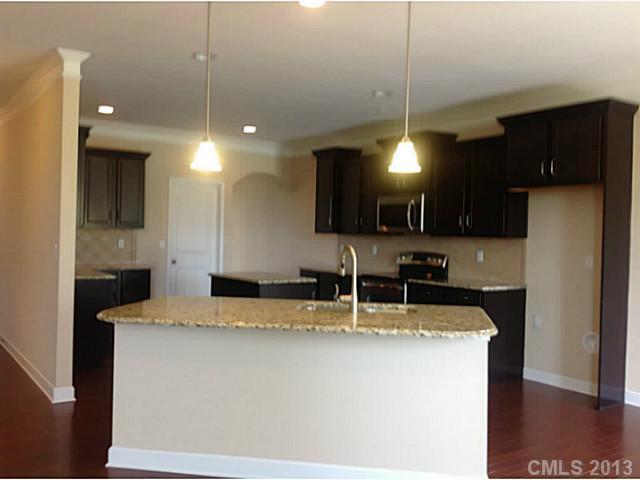 78004 Rillstone Drive, Unit 181 Lancaster, SC 29720 - Photo 8 of 13 a kitchen with kitchen island a sink stainless steel appliances and cabinets