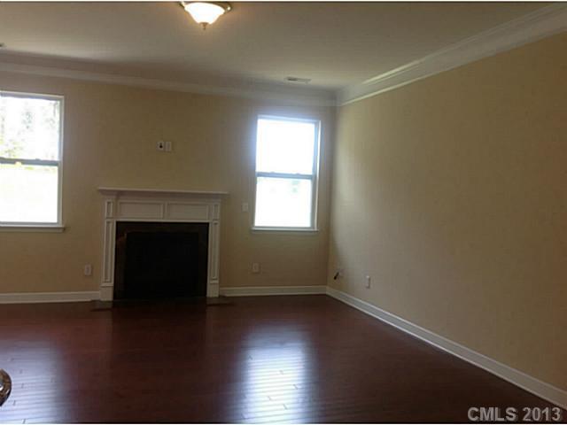 78004 Rillstone Drive, Unit 181 Lancaster, SC 29720 - Photo 9 of 13 an empty room with wooden floor and fireplace