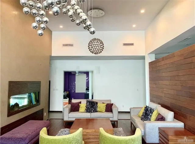 a living room with furniture a chandelier and a fireplace
