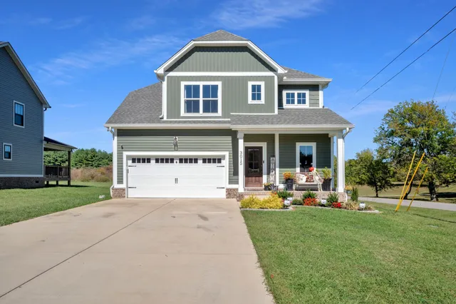 a front view of a house with a yard and trees