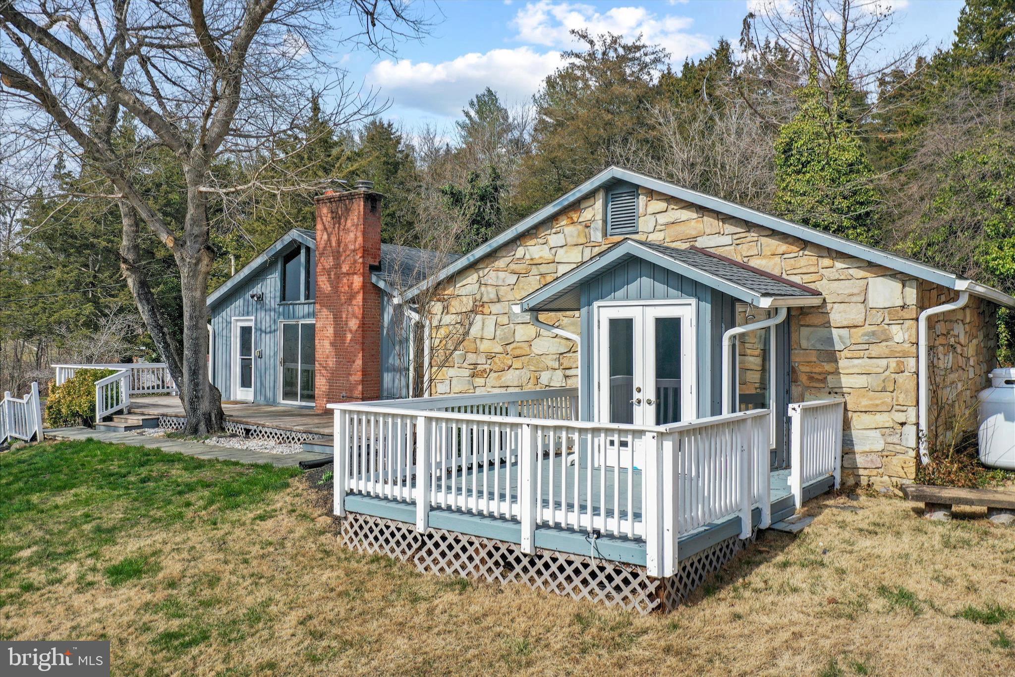 a view of a house with a yard and large trees