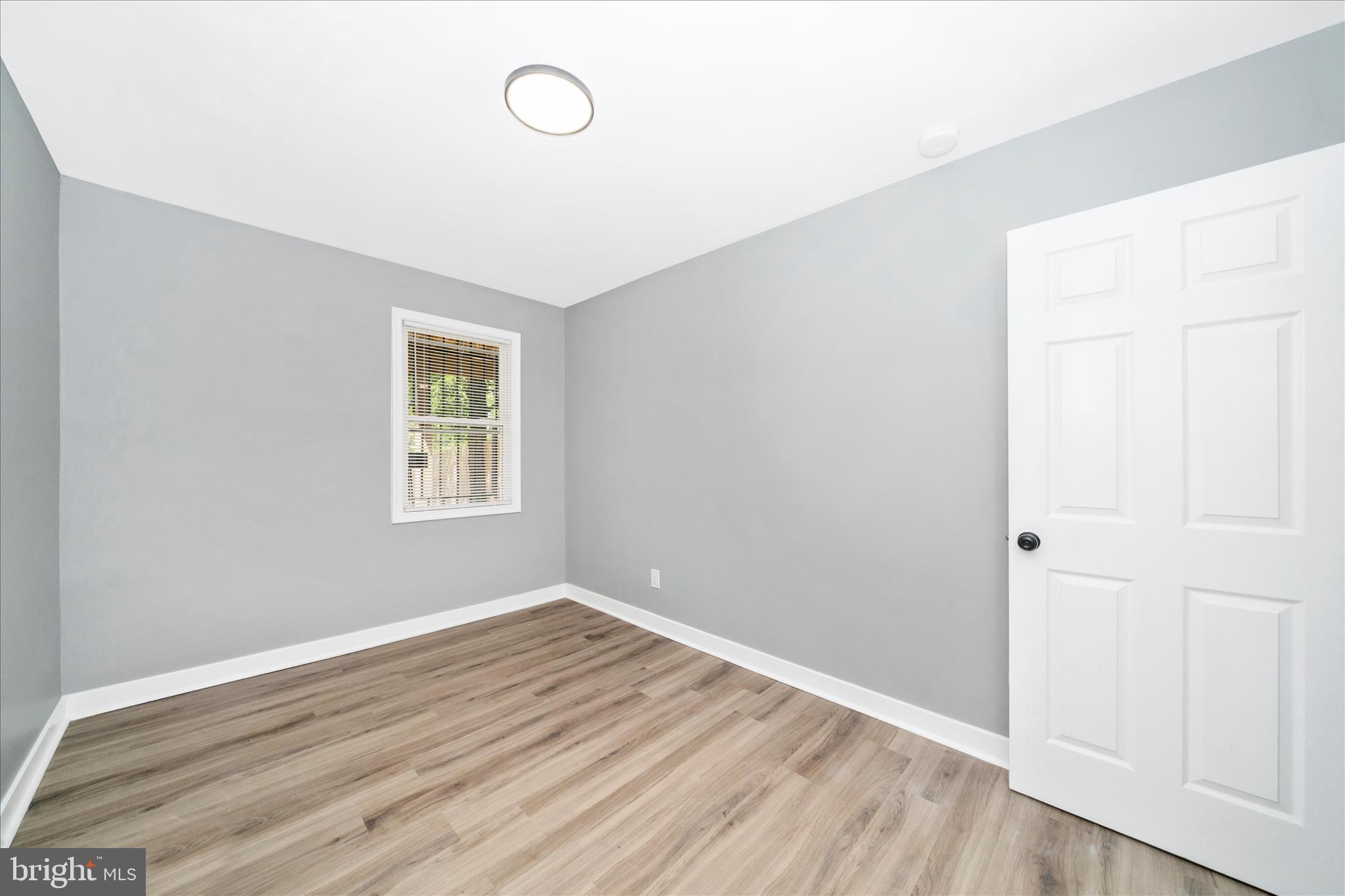 5027 Benning Road Southeast Washington, DC 20019 - Photo 25 of 57 an empty room with wooden floor and windows