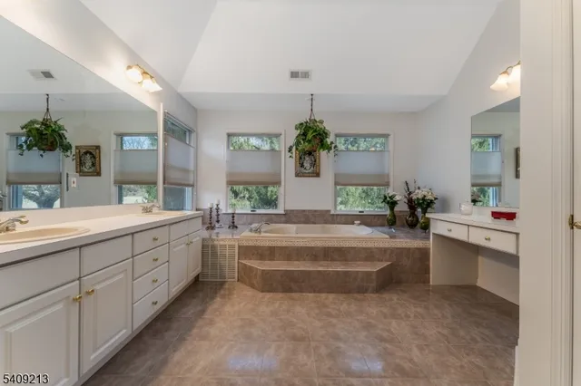 a spacious bathroom with a granite countertop sink and a mirror