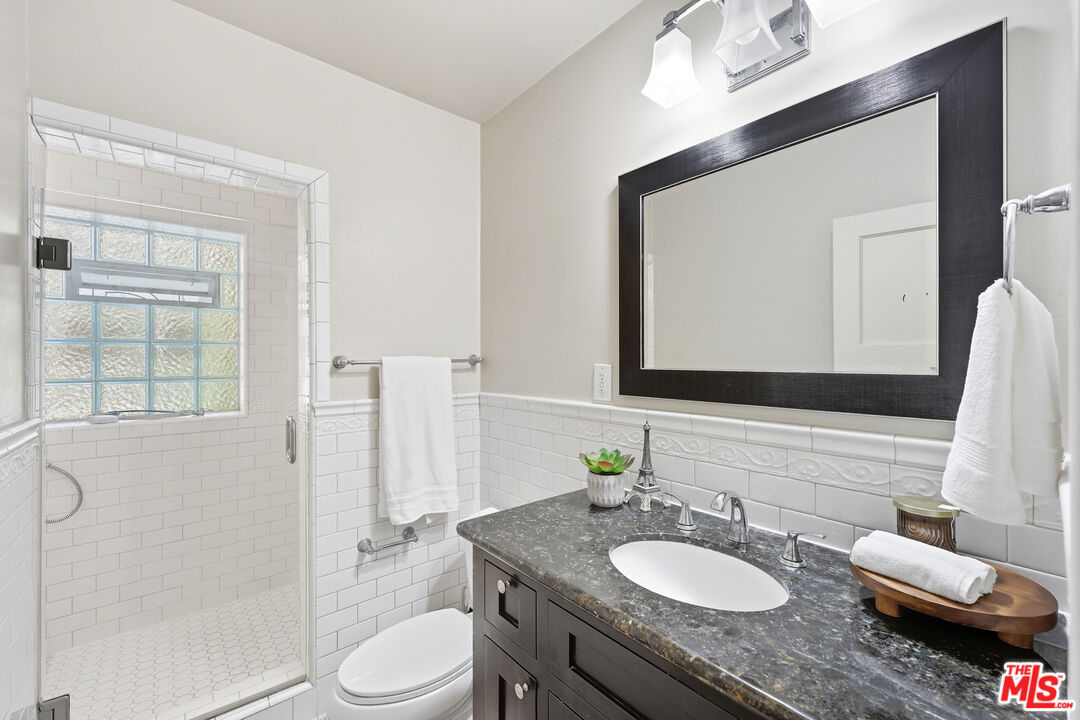804 Hillcrest Street El Segundo, CA 90245 - Photo 12 of 34 a bathroom with a granite countertop sink toilet a mirror and shower
