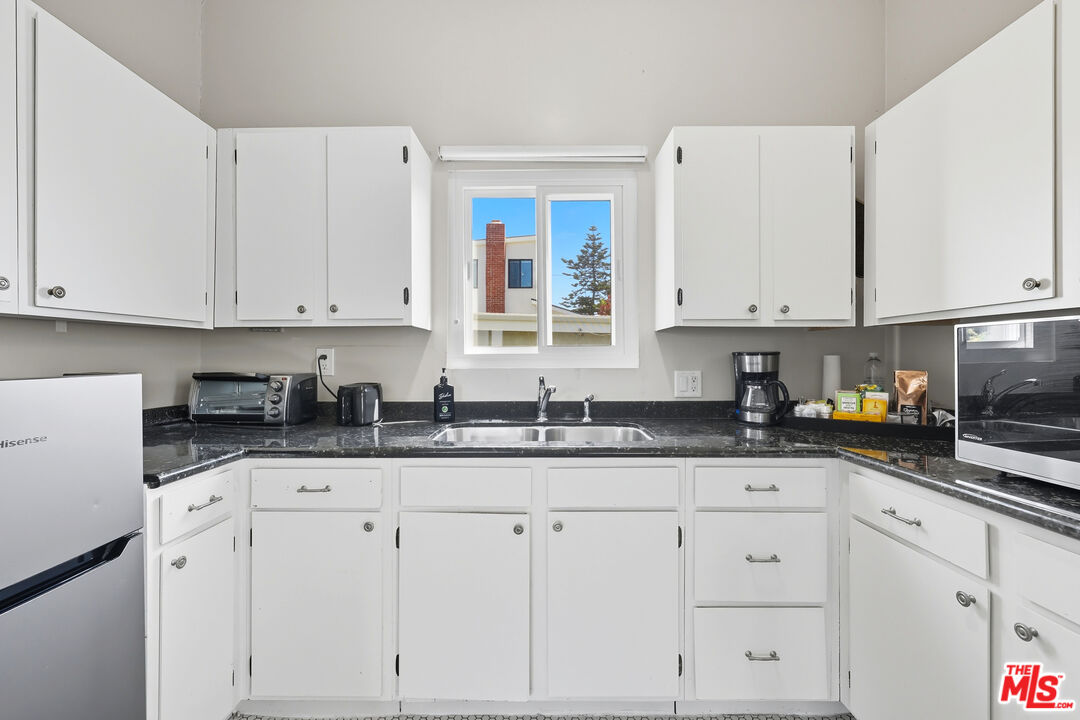 804 Hillcrest Street El Segundo, CA 90245 - Photo 21 of 34 a kitchen with granite countertop white cabinets and white appliances
