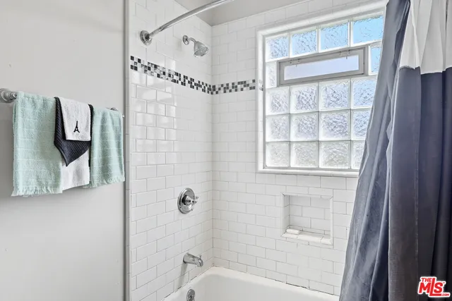 a bathroom with a window and a shower